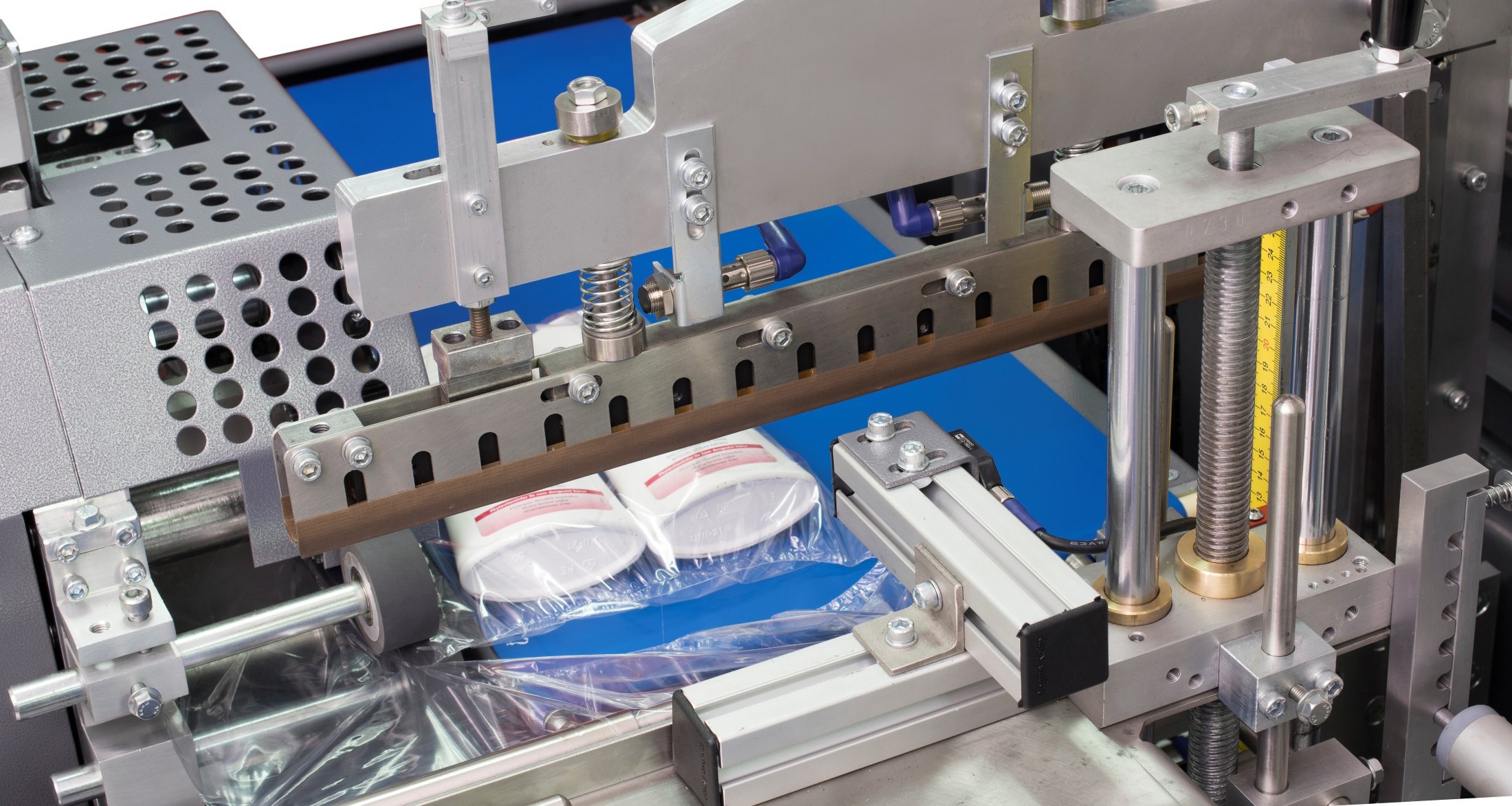 Shrink-wrapping machinery sealing grouped products in clear film